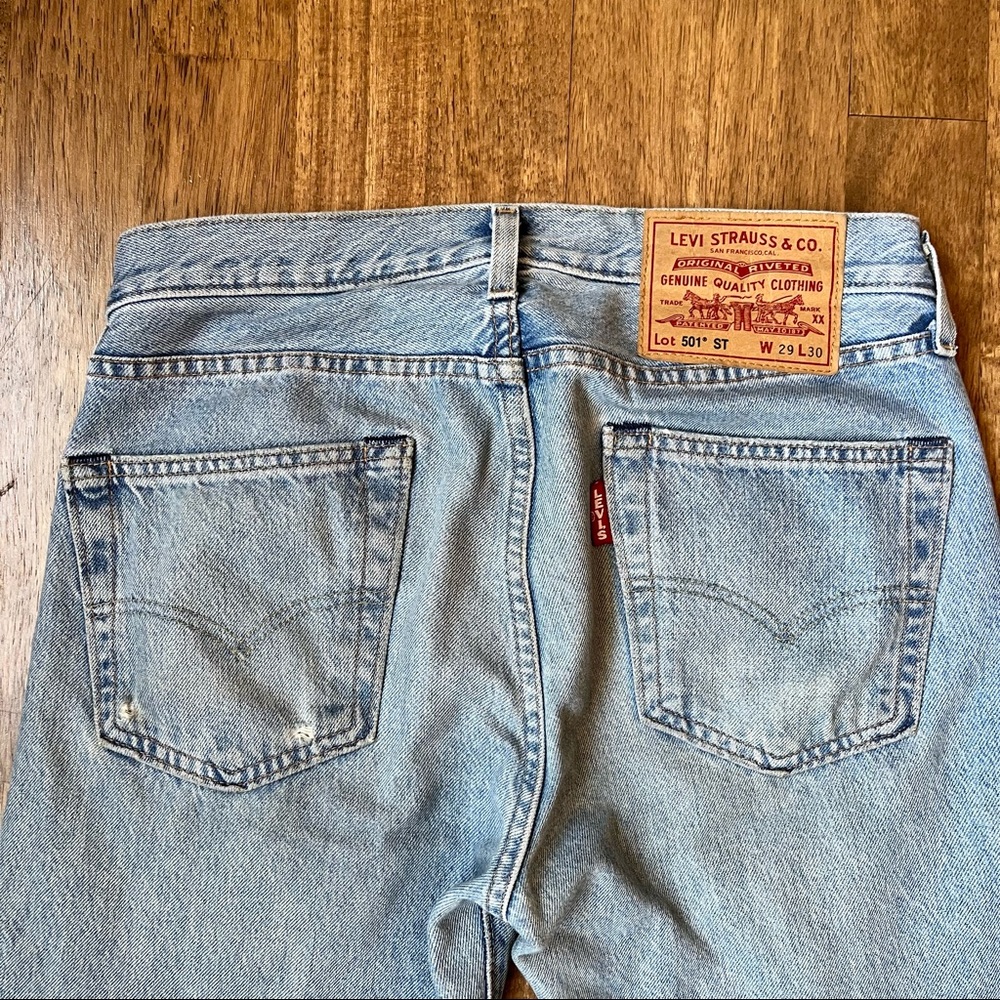 Levi’s 501 Slim Taper in light wash with distressing. Size 29x30.